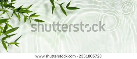 spa background banner with green bamboo leaf on white transparent water wave in sunlight, beautiful concept wallpaper with copy space for travel or cosmetics Royalty-Free Stock Photo #2351805723