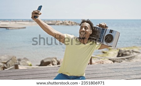 African american man holding boombox make selfie by smartphone at seaside