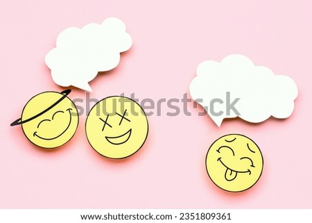 Paper faces with blank speech bubbles on pink background