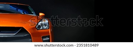 Orange modern car headlights on black background, copy space, banner side	 Royalty-Free Stock Photo #2351810489