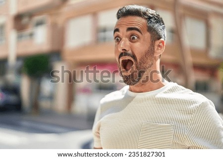Young hispanic man standing with surprise expression at street Royalty-Free Stock Photo #2351827301