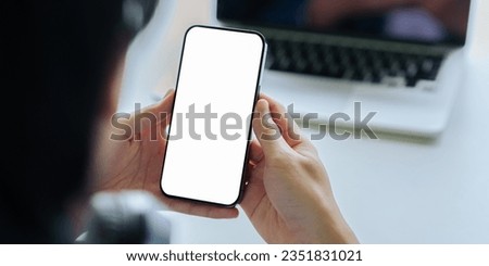 Close up young man hand holding a smartphone blank white screen at the home. mock up