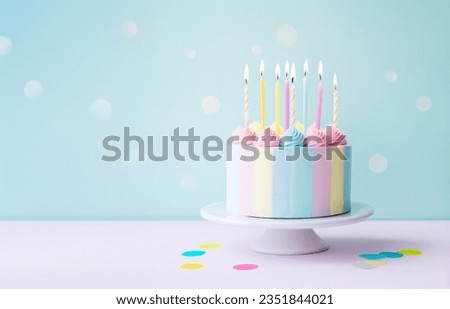 Birthday cake decorated with pastel colored buttercream and eight birthday cake candles against a pastel background