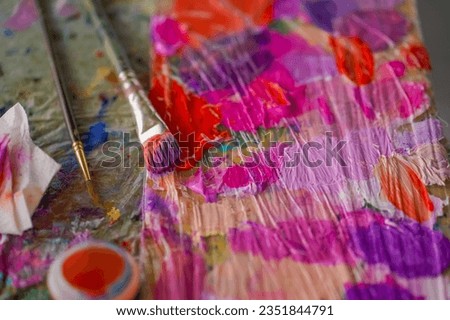 close-up of paint palettes with traces of oil paint on them and a brush lying next to them in studio for painting the concept of love of fine art
