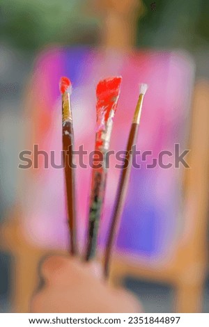 Close-up of three painting brushes of different sizes in paint the concept of admiration for oil painting