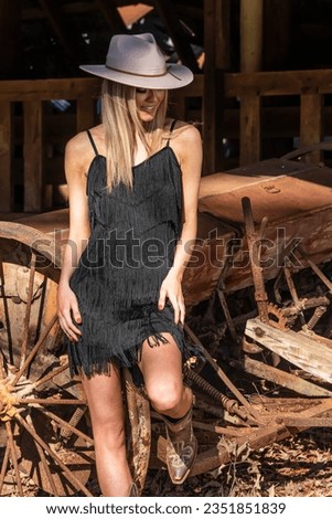 A gorgeous blonde cowgirl model poses outdoors while enjoying the spring weather Royalty-Free Stock Photo #2351851839