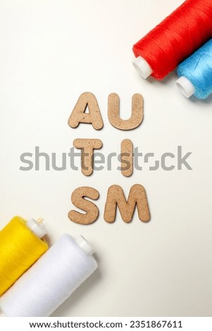 Multicolored threads with the word "autism" on a white background. World autism day concept