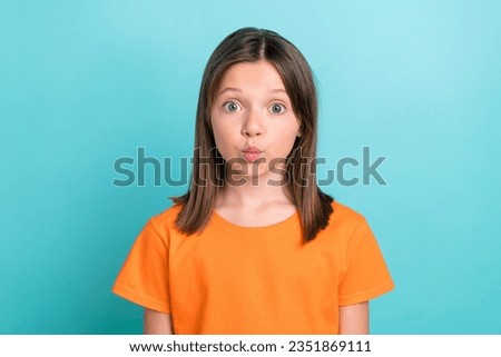 Portrait of friendly schoolgirl with straight hairdo dressed orange t-shirt pouted lips send kiss isolated on turquoise color background