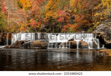 River waterfall in the autumn forest. Autumn river waterfall. Waterfall in autumn forest. Autumn forest river waterfall landscape