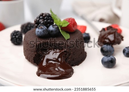 Delicious chocolate fondant, berries and mint on plate, closeup Royalty-Free Stock Photo #2351885655