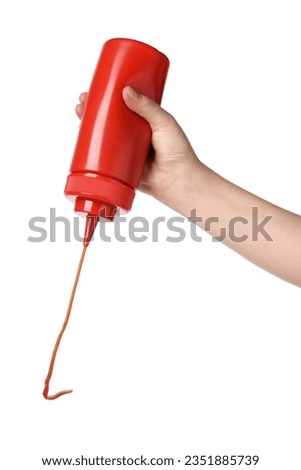 Woman pouring tasty ketchup from bottle on white background, closeup Royalty-Free Stock Photo #2351885739