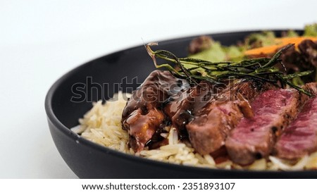Juicy New York strip beef steak with special sauce, buttery rice, and vegetables Royalty-Free Stock Photo #2351893107
