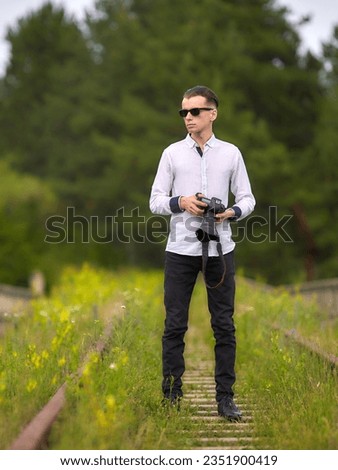 Young photographer man using professional camera at park. Young photographer man thinking an idea.
