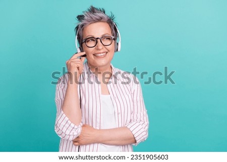 Portrait of clever young lady wear white striped shirt looking empty space minded working with headset isolated on blue color background Royalty-Free Stock Photo #2351905603