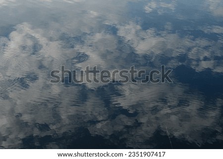 Clouds. Reflection of clouds in blue water.