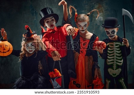 Group of children, little boys and girls in stylish costumes for halloween and creepy makeup over dark vintage background. Concept of Halloween, childhood, celebration, party, holiday, creativity, ad