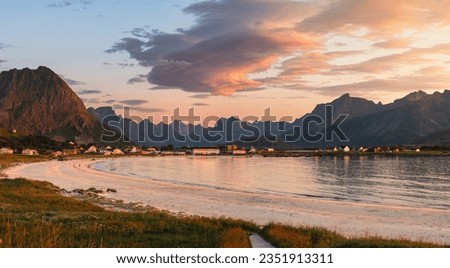 Beautiful sunset over Ramberg beach in summer, Lofoten, Norway. Fantastic sky colors and cloud formation over the mountain peaks.