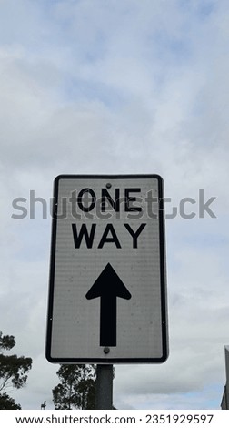 A One Way sign with arrow indicating straight ahead.