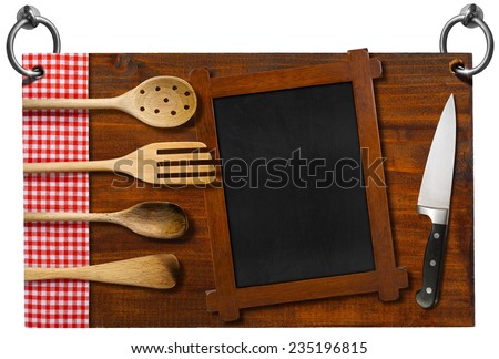 Advertising dark wooden sign for a restaurant with four wooden kitchen utensils, fork, spoons, ladles on red and white checkered tablecloth, empty blackboard and kitchen knife
