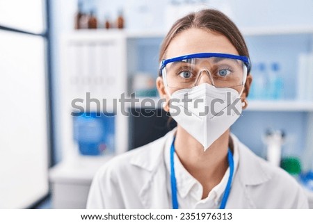 Young caucasian woman scientist wearing medical mask at laboratory