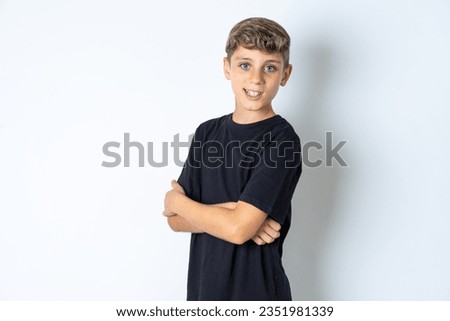 Portrait of Beautiful kid boy wearing black casual t-shirt standing with folded arms and smiling Royalty-Free Stock Photo #2351981339