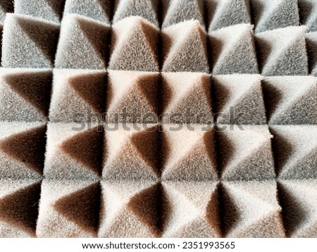 Foam soft texture and background with lots of pyramids, triangles. Frame, place for text and copy space. The difference of light and shadow