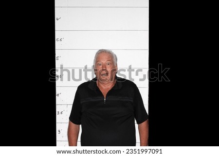 Photo Booth. A man is Shocked and upset as his Mugshot Photos are taken during an arrest. A man Poses in a Photo Booth against a Mugshot Photo board. People love Photo Booth. Funny Photos. Pictures. 