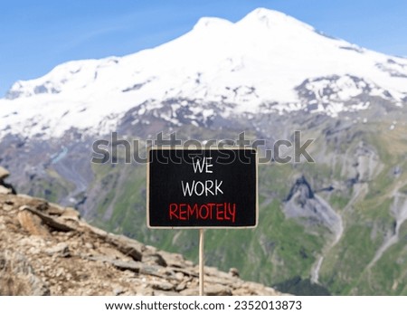 We work remotely symbol. Concept words We work remotely on beautiful black chalk blackboard. Beautiful mountain Elbrus background. Business we work remotely remote work concept. Copy space.