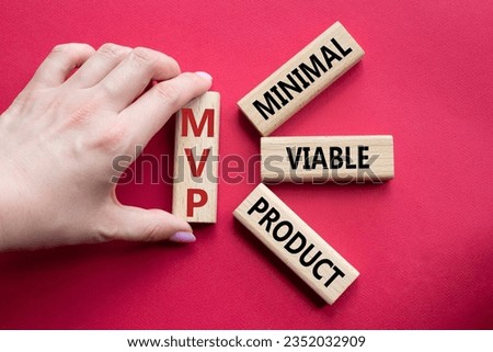 MVP - Most Valuable Player symbol. Wooden cubes with words MVP. Businessman hand. Beautiful red background. Business and MVP concept. Copy space.