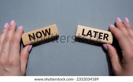 Now vs Later symbol. Concept word Now vs Later on wooden blocks. Businessman hand. Beautiful grey background. Business and Now vs Later concept. Copy space Royalty-Free Stock Photo #2352034189
