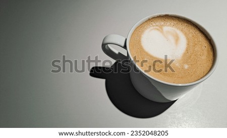 Latte art with a heart shape served with a white cup with a vignetting background