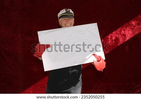 Photo Booth. A Man holds a Blank White Sign while posing and smiling in a Photo Booth at a Party. Blank White Sign with room for your text or images. Everyone loves a Photo Booth at a party or event. 