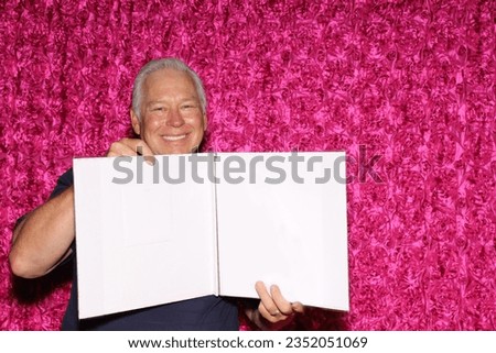 Photo Booth. A Man holds a Blank White Sign while posing and smiling in a Photo Booth at a Party. Blank White Sign with room for your text or images. Everyone loves a Photo Booth at a party or event. 