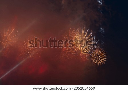 Beautiful fireworks explodes in night city sky above and though smoke cloud. Pyrotechnic display. Copy space for your text or decoration. Holiday celebration theme.