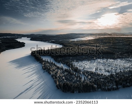 Aerial view over a frozen river in northern Sweden on a cold winter day Royalty-Free Stock Photo #2352066113