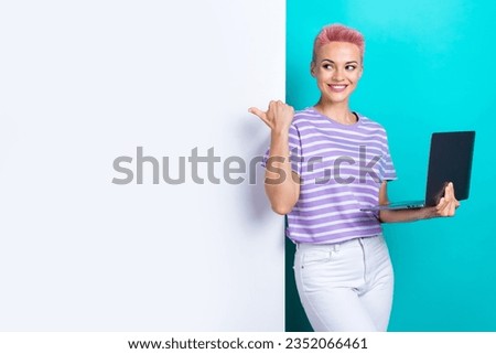 Portrait of charming positive lady hold netbook look direct finger empty space ad poster isolated on turquoise color background