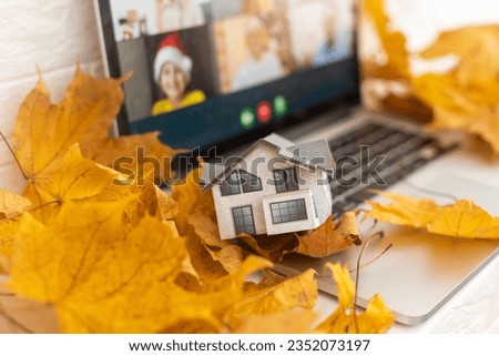 dry autumn leaves and laptop and toy house