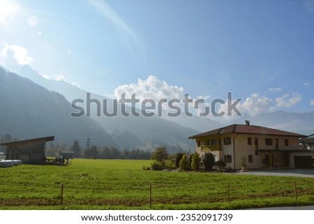 There is a barn near the village cottage. Mountains in the background. Picturesque nature and architecture outside the city