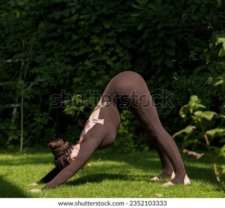 woman meditates doing yoga exercises in park garden.yoga on green nature background.