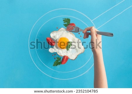 Fried egg food styling with tomatoes cherry and persil in pan drawn by chalk hand in taking a piece with fork
