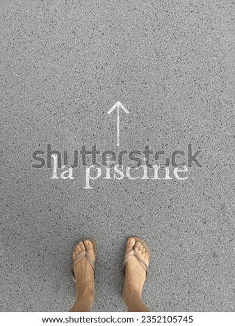 woman's feet from above on concrete background near the inscription indicating the entrance to the swimming pool. High quality photo