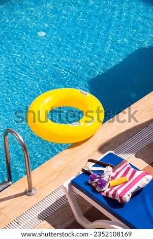 Closeup detail of a white blank sunbed by the swimming pool in a hot summer day. Summer vacation destination. Royalty-Free Stock Photo #2352108169