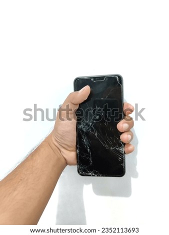 holding a smartphone with a cracked screen, on a white background. Man holding mobile phone with broken screen