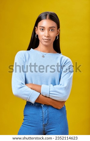 Arms crossed, fashion and student with portrait of woman in studio for future, pride and serious. Youth, confident and college with Indian person on yellow background for learning and trendy style Royalty-Free Stock Photo #2352114623