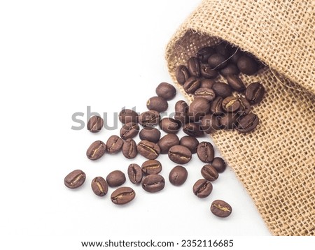 Roasted coffee beans with burlap cloth on white background