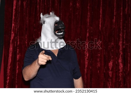 Photo Booth. Unidentifiable People wear Horse Head Masks and pose and play while their pictures are taken in a Photo Booth. Party Photo Booth. Wedding Photo Booth. Holiday. Horsing Around. Fun Times.