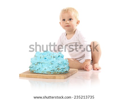 A one year old baby boy smashing a blue iced birthday cake on a wooden board. Image is isolated on a white background.