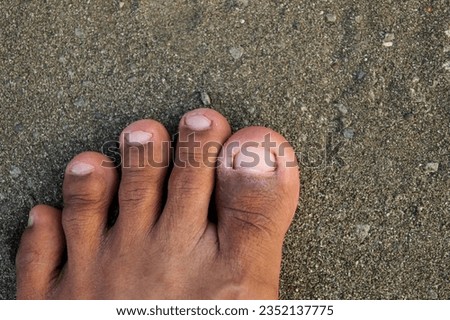 man's feet stepping on the sand