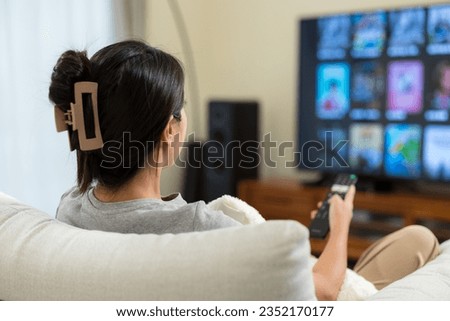 Woman watch TV at home Royalty-Free Stock Photo #2352170177