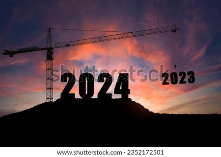 Happy New Year 2024 concept, Silhouette of engineer and construction to build lifting crane 2023 on purple yellow sky background.
